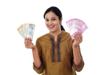 Young Indian woman holding currency notes agianst white background