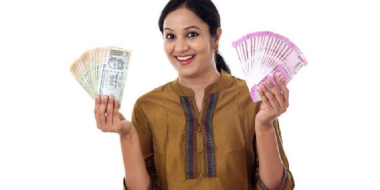 Young Indian woman holding currency notes agianst white background