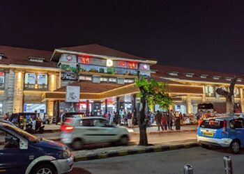 Pune, India: Vehicles are running  and passengers are moving in lane outside Pune railway station at night. Pune is second biggest Information technology hub of India and second largest city of Maharashtra state in India.