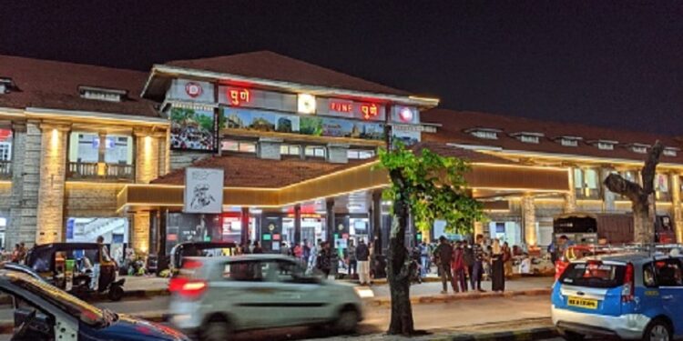 Pune, India: Vehicles are running  and passengers are moving in lane outside Pune railway station at night. Pune is second biggest Information technology hub of India and second largest city of Maharashtra state in India.