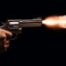 A revolver held by two anonymous hands is fired on a black background.